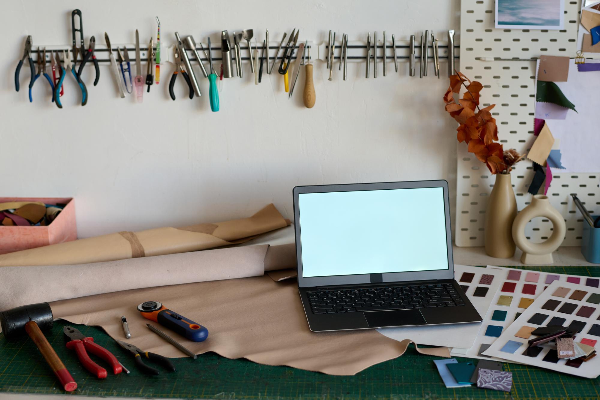 Tavolo con materiali per ricamo e laptop